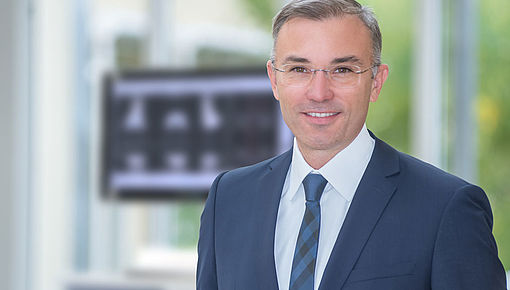 Professor Renkawitz vor einem Robotik Screen