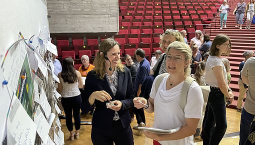 Frauen sprechen vor Schautafeln