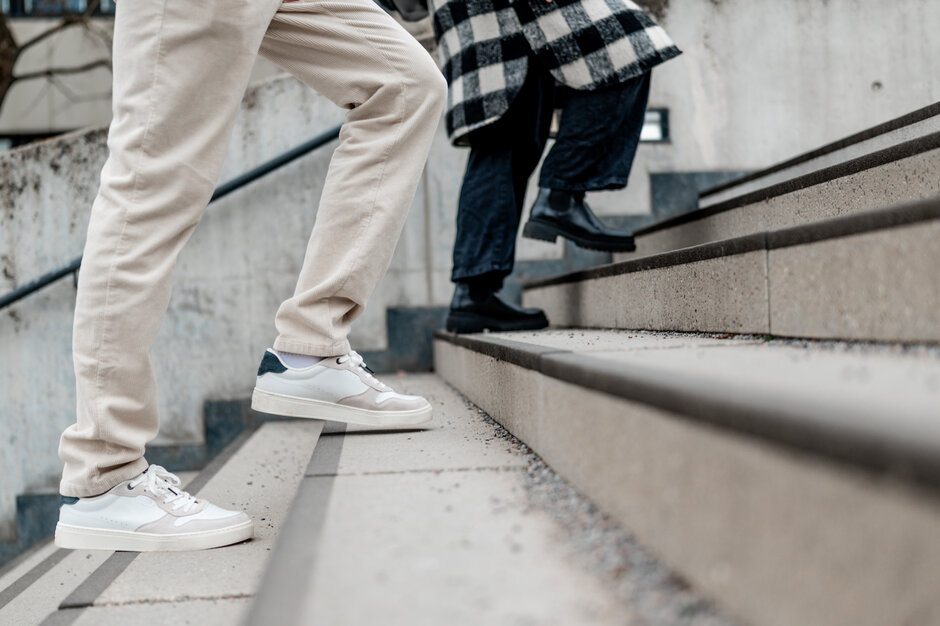 Zwei Personen gehen eine Treppe hinauf.
