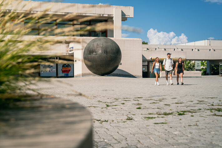 Studierende gehen über das Forum am Campus der Universität Regensburg. (öffnet Vergrößerung des Bildes)