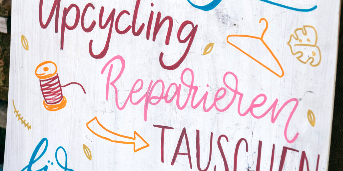 Ein buntes Plakat, in dem im Stil des Handlettering geschrieben steht: "Netzwerk Nachhaltigkeit - Upcycling - Reparieren - Tauschen - für mehr Suffizienz"