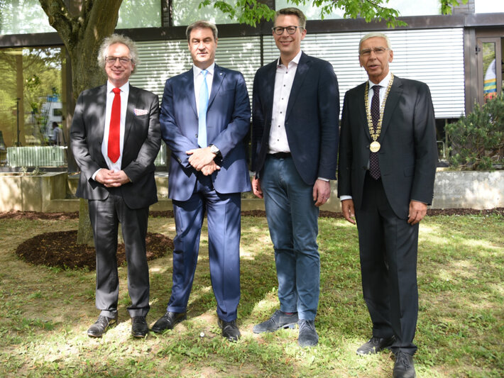 Vier Männer in formeller Kleidung posieren in einer Reihe für ein Gruppenfoto. Der Mann ganz rechts trägt einen Amtskette. (öffnet Vergrößerung des Bildes)