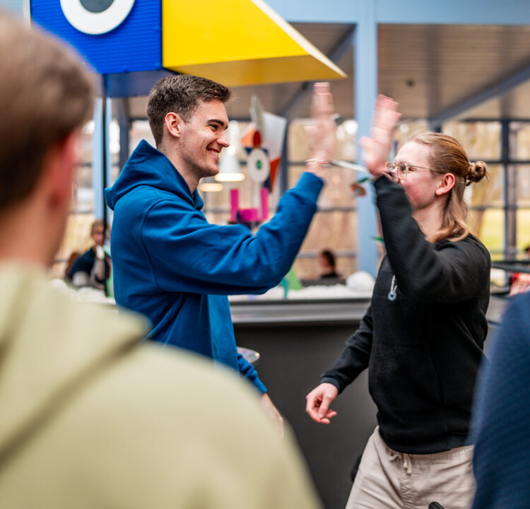 Zwei Studenten klatschen sich mit der Geste "High Five" ab