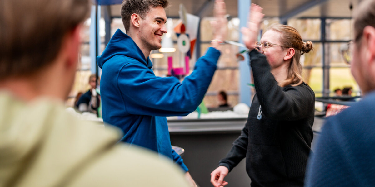Zwei Studenten klatschen sich mit der Geste "High Five" ab