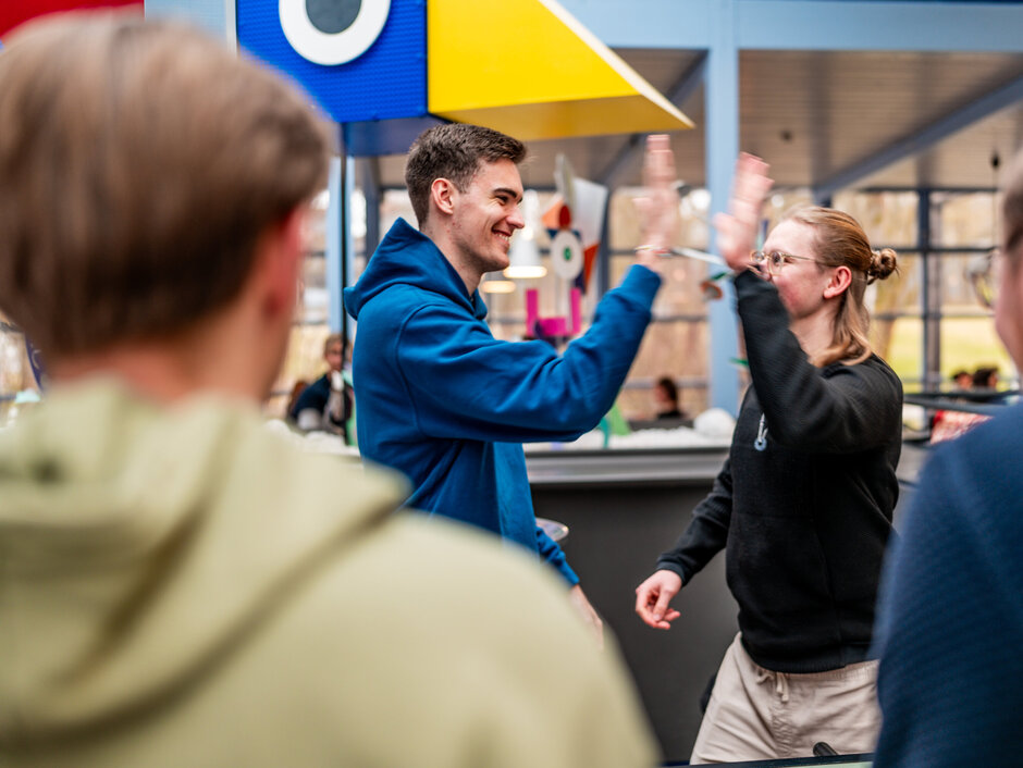 Zwei Studenten klatschen sich mit der Geste "High Five" ab