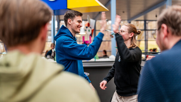 Zwei Studenten klatschen sich mit der Geste "High Five" ab