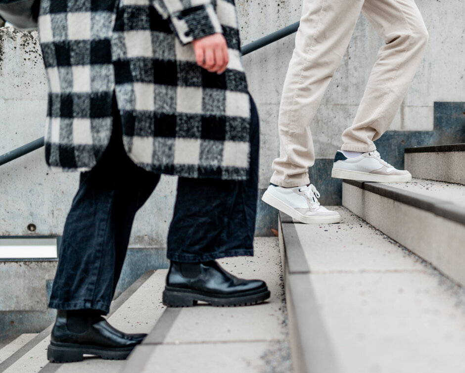 Zwei Menschen gehen eine Treppe hinauf.